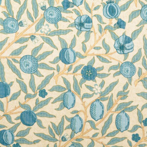 Flach ausgebreiteter Baumwollstoff für Kleidung mit detailliertem Granatapfel-Print in Blautönen auf beigem Hintergrund, symmetrisch arrangiertes botanisches Muster.