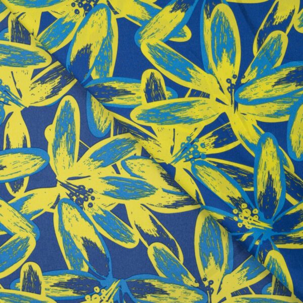 Polyester Stoff für Blusen in Blau-Gelb mit Blumenmuster, eine Stoffkante leicht übergeschlagen.